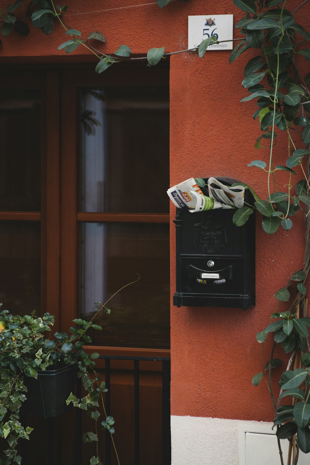 black mail box mounted on brown brick wall