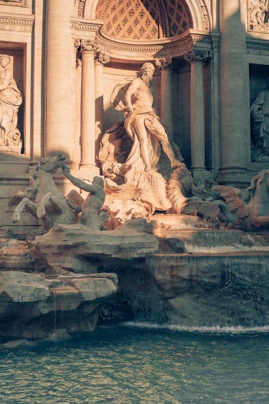 gray concrete statue of man and woman in Trevi Fountain Italy