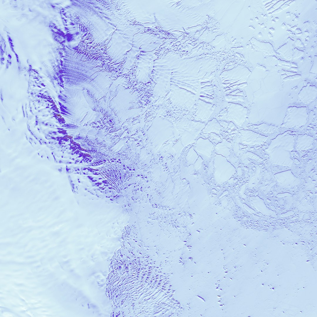 Lines and shapes etched into the surface of Antarctica's Robinson Glacier hint at the slow but inevitable movements of this giant river of ice. Patterns of lines may be icefalls, where a glacier cascades over rock, or a series of crevasses, massive cracks that form as different parts of a glacier move at slightly different speeds. Robinson Glacier flows down to the continent's coast, where glacial ice meets mammoth slabs of sea ice caught in the frigid embrace of the Southern Ocean.
