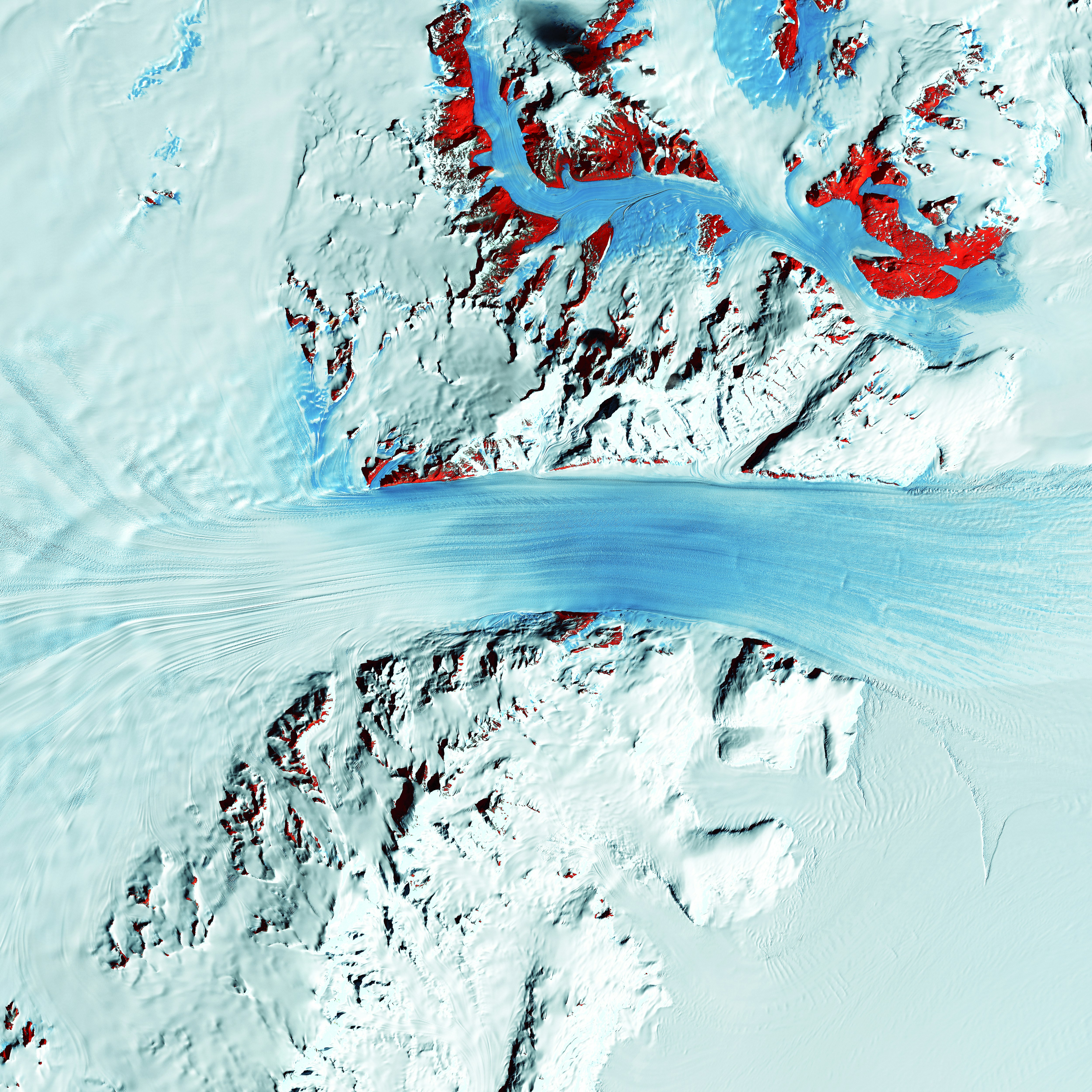 Truly a river of ice, Antarctica's relatively fast-moving Byrd Glacier courses through the Transantarctic Mountains at a rate of 0.8 kilometers (0.5 miles) per year. More than 180 kilometers (112 miles) long, the glacier flows down from the polar plateau (left) to the Ross Ice Shelf (right). Long, sweeping flow lines are crossed in places by much shorter lines, which are deep cracks in the ice called crevasses. The conspicuous red patches indicate areas of exposed rock.