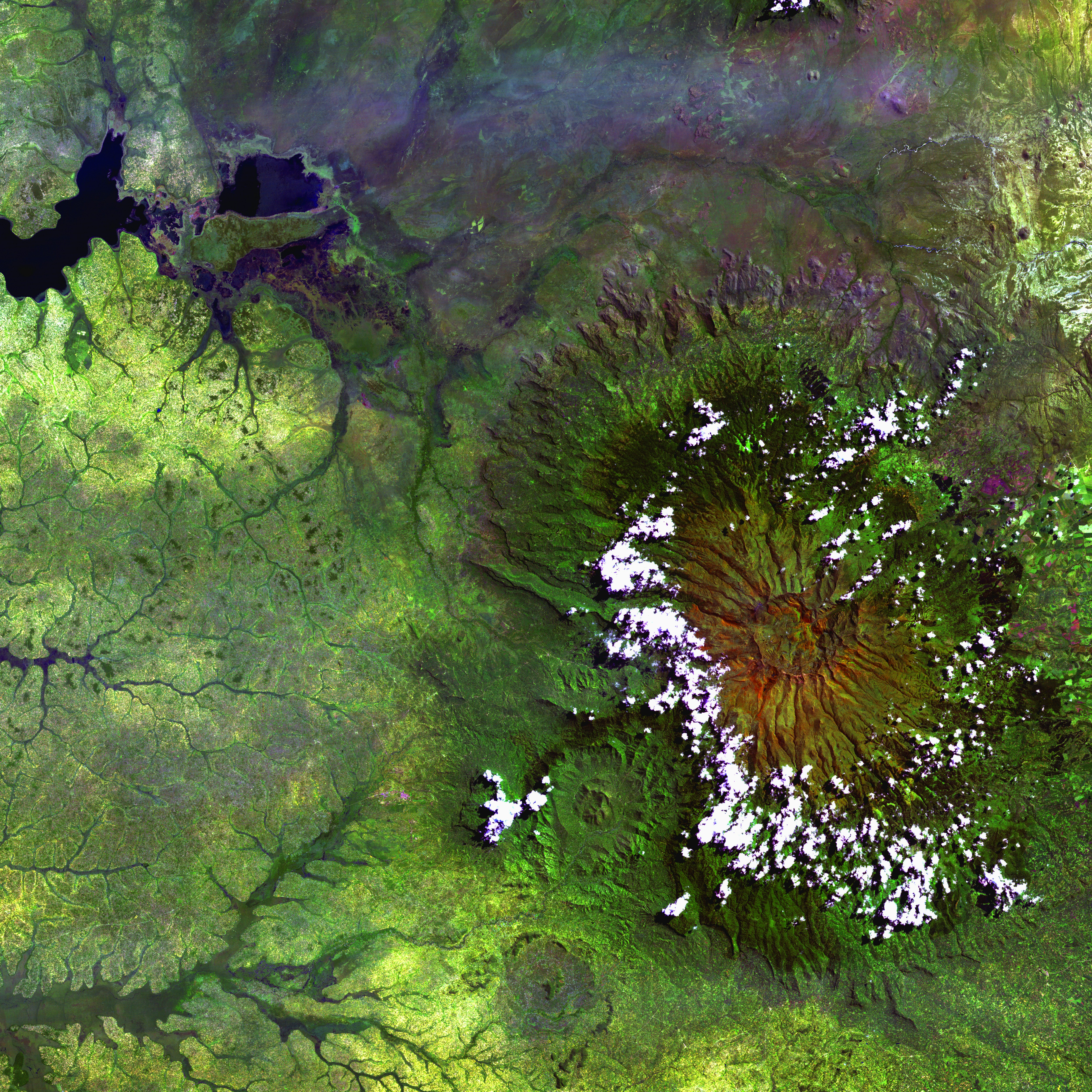 Clouds encircle the lofty rim of Africa's Mount Elgon, a huge, long-extinct volcano on the border between Uganda and Kenya. The solitary volcano has one of the world's largest intact calderas, a cauldron-like central depression. The caldera is about 6.5 kilometers (4 miles) across and formed following an eruption, when the emptied magma chamber collapsed under the weight of volcanic rock above it.