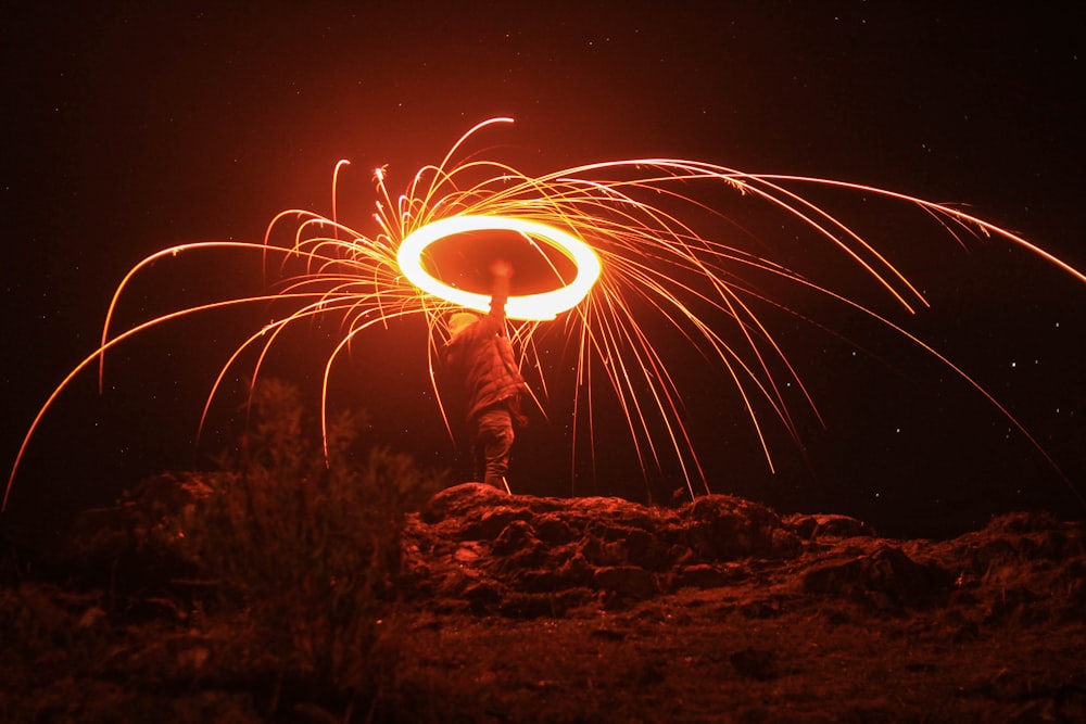 man standing on brown rock holding lighted light