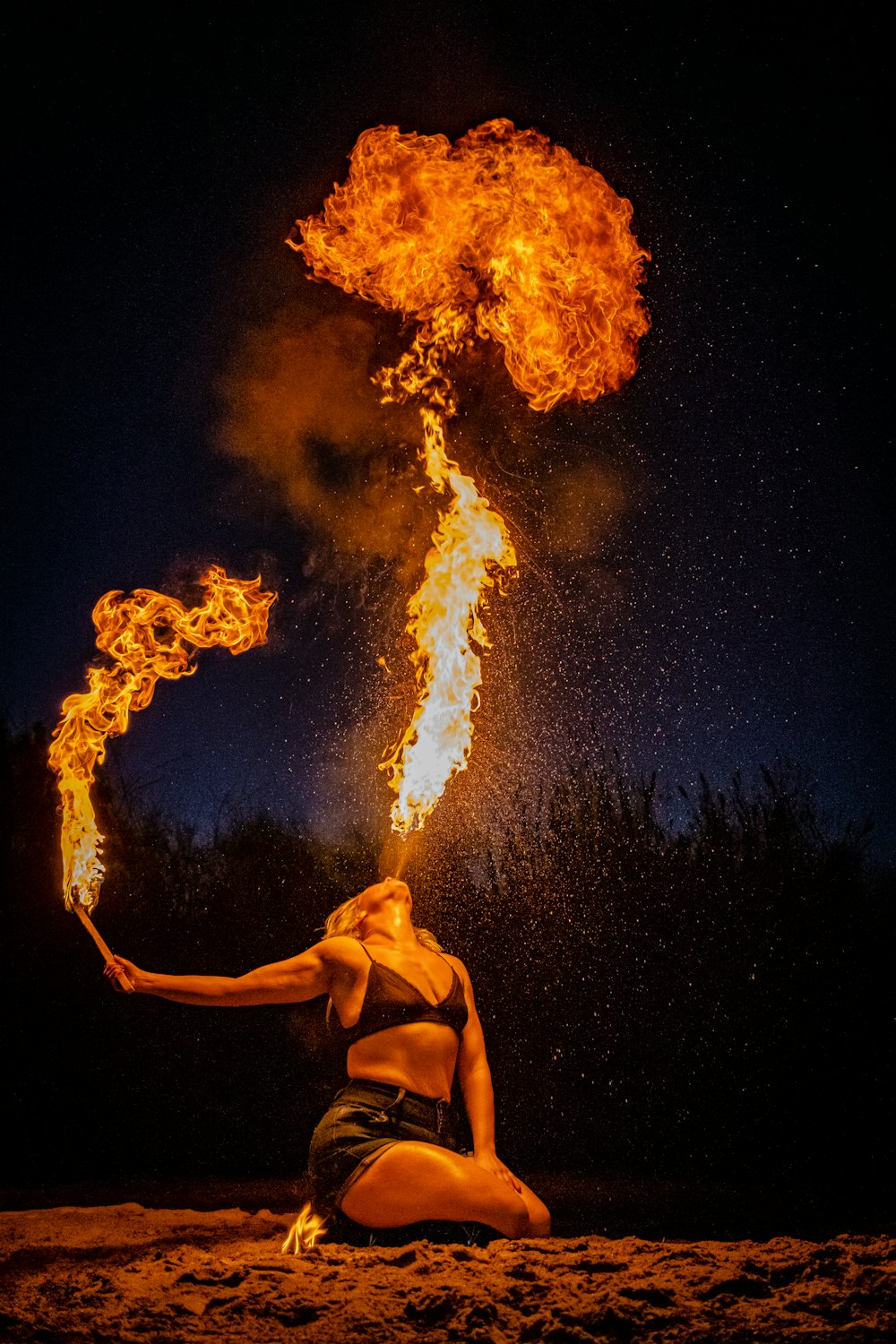 man in black shorts standing in front of fire