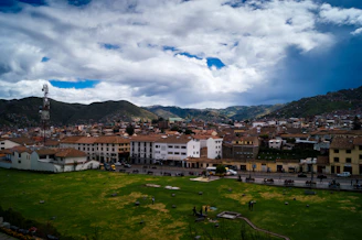 white and brown concrete buildings under white clouds and blue sky during daytime