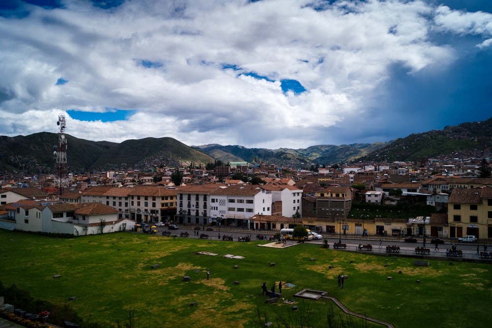 white and brown concrete buildings under white clouds and blue sky during daytime