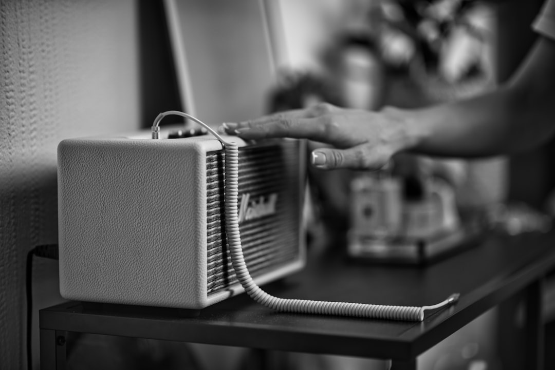 grayscale photo of person holding radio
