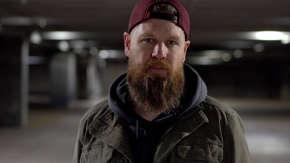 man in gray jacket and red cap