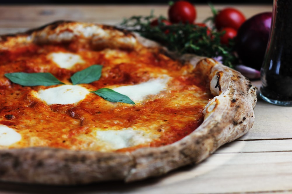 pizza with tomato and green leaves