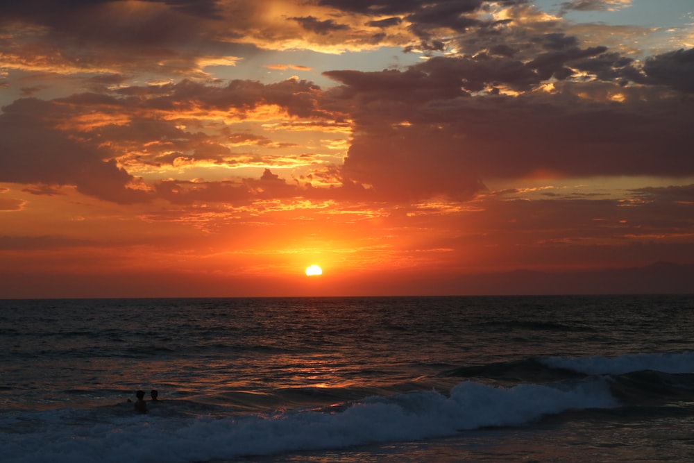 silhouette of people on beach during sunset