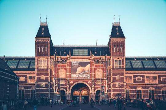 people walking near brown concrete building during daytime in Rijksmuseum Netherlands