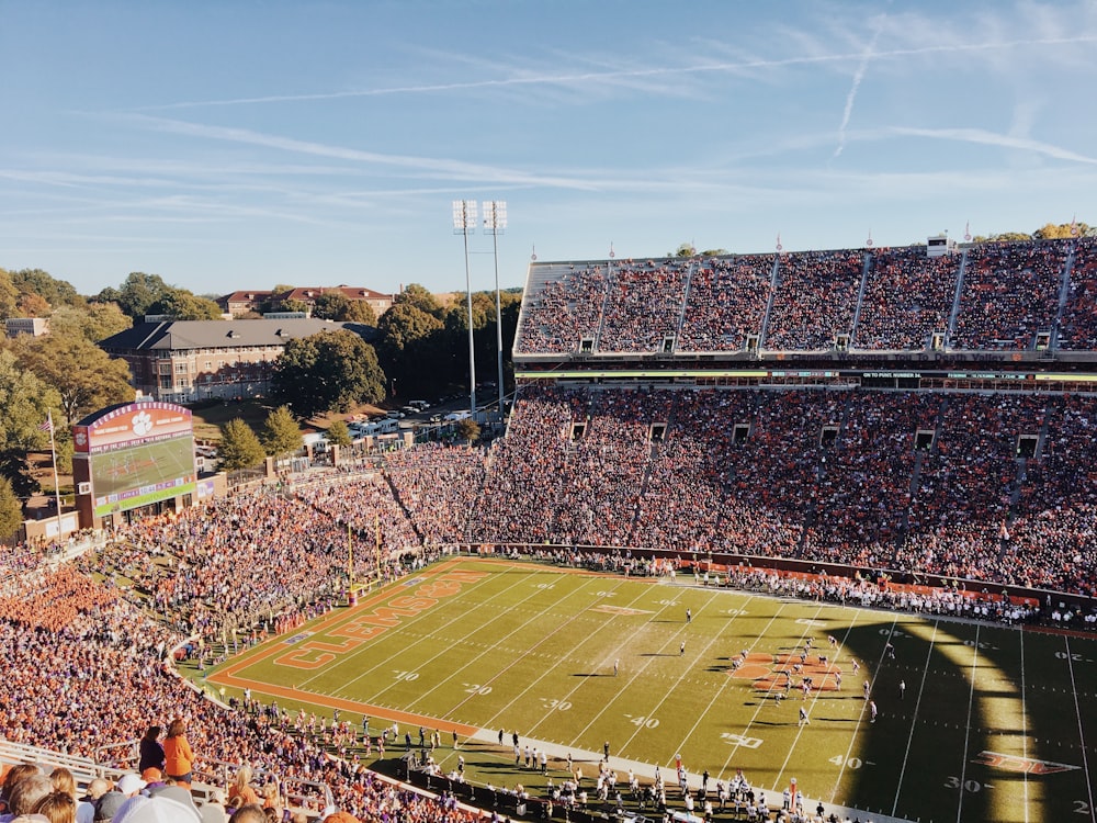 people watching football game during daytime