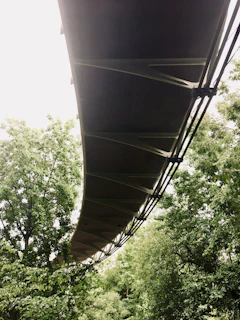 A sturdy PRFV pultruded bridge spanning a small river, surrounded by lush greenery.