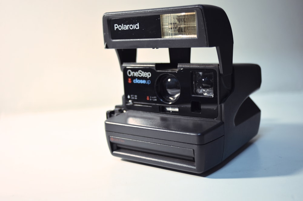 black polaroid instant camera on white table