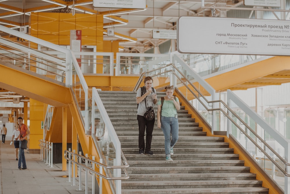 woman in black shirt and blue denim jeans standing on stairs