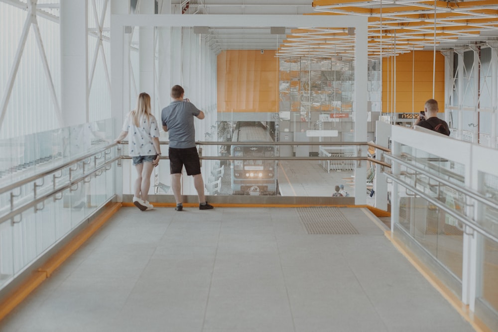 man in black shirt and pants walking on white ceramic floor tiles