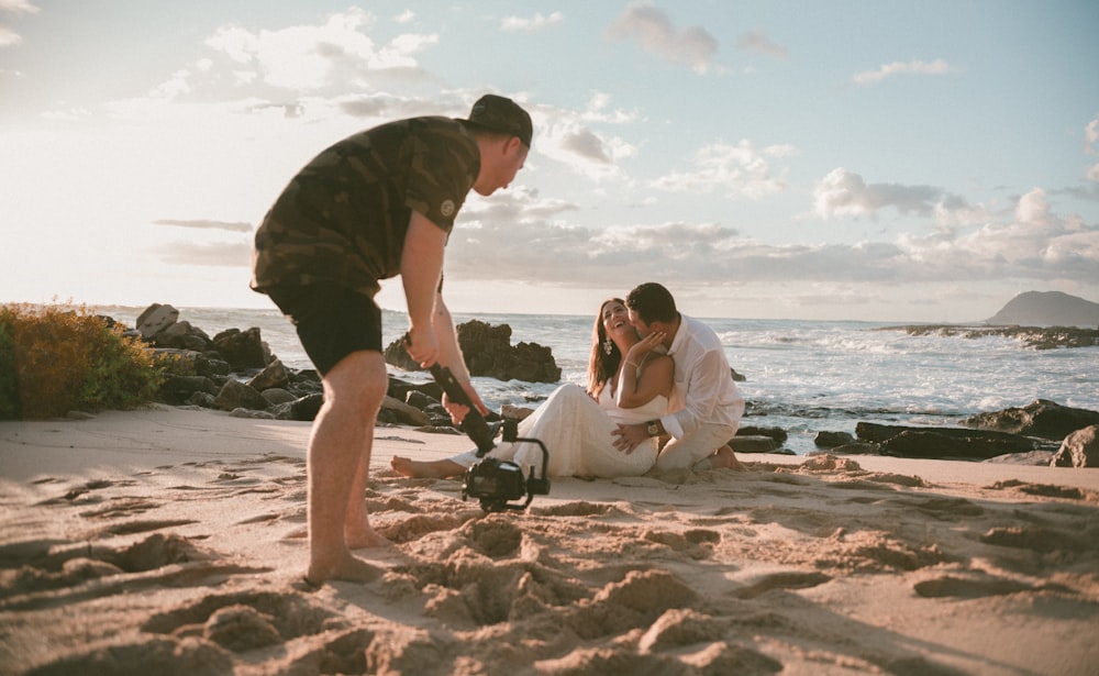 man and woman sitting on beach shore during daytime