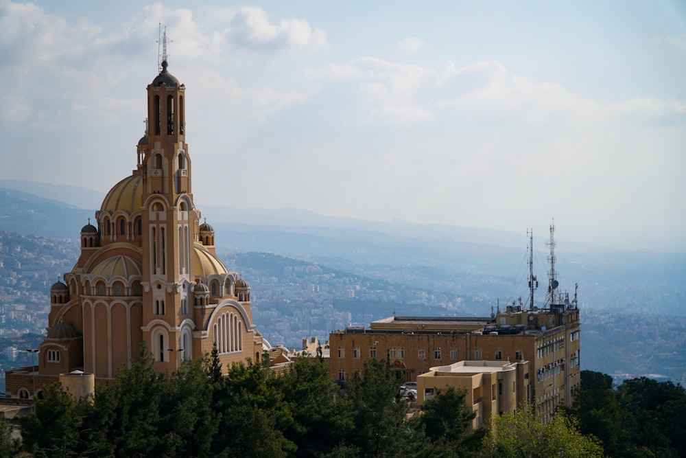 edificio in cemento marrone vicino agli alberi verdi durante il giorno