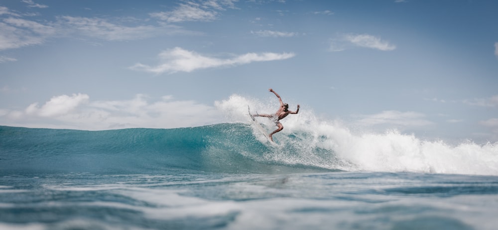 man surfing on sea waves during daytime