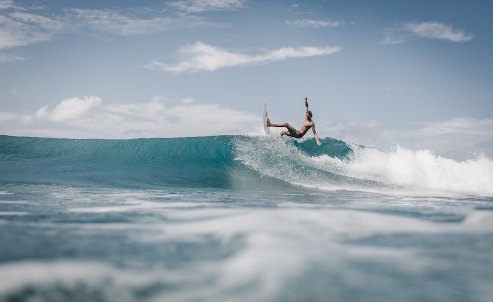 man surfing on sea waves during daytime