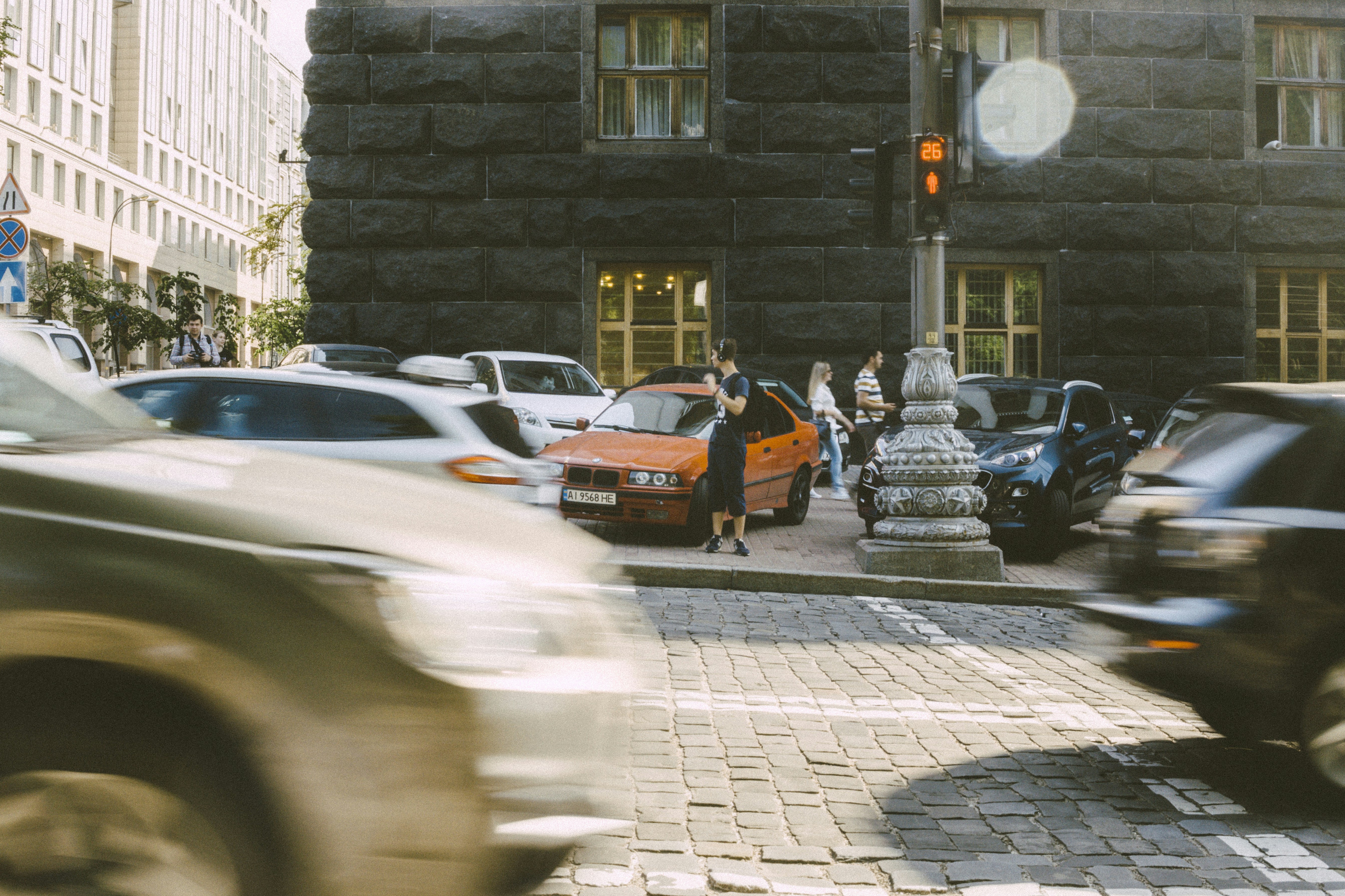 cars parked beside brown brick building during daytime