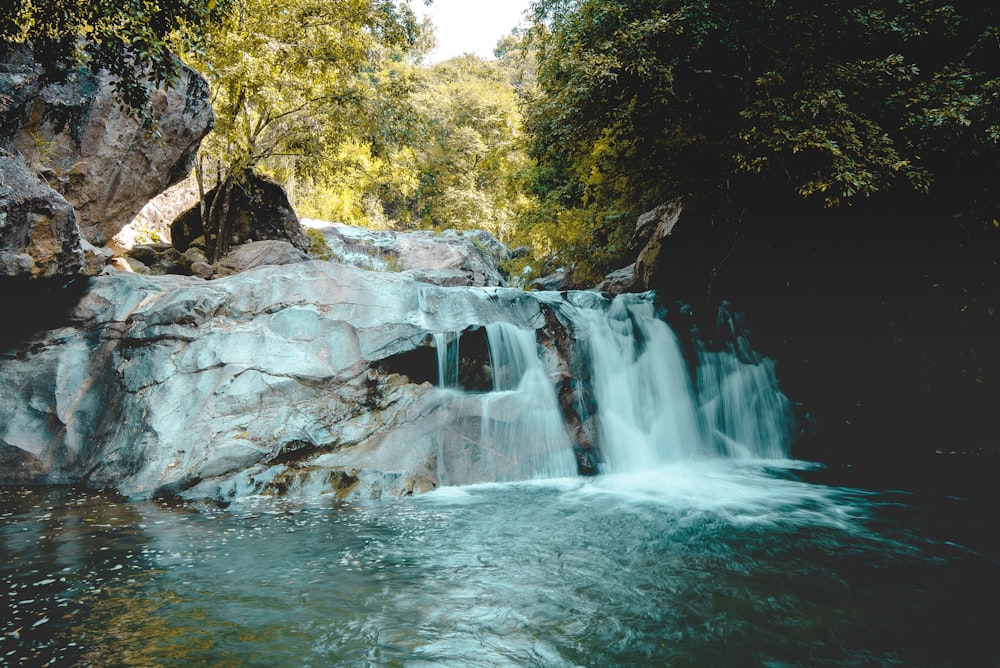 waterfalls in the middle of the forest during daytime