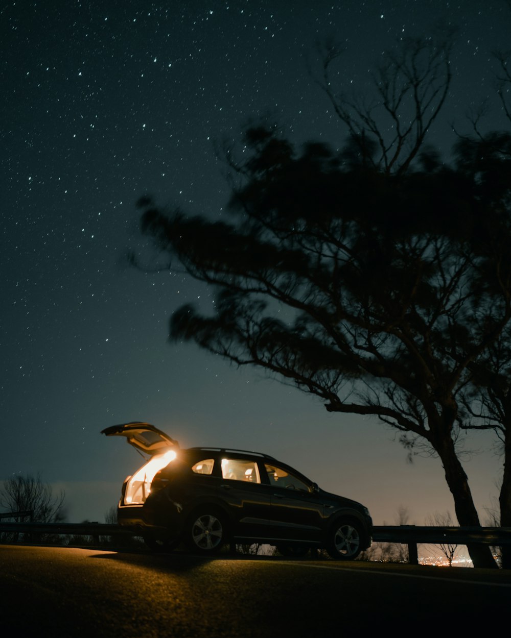 white suv parked beside tree during night time