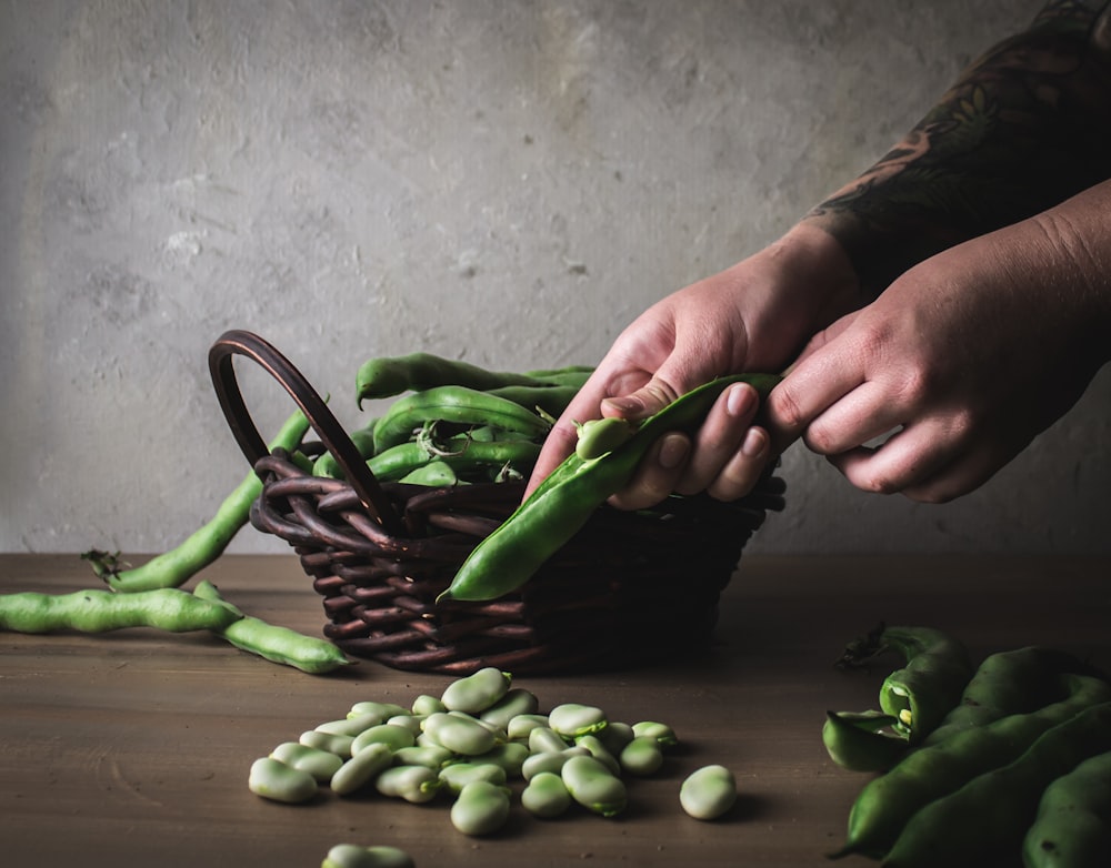 person holding green chili peppers