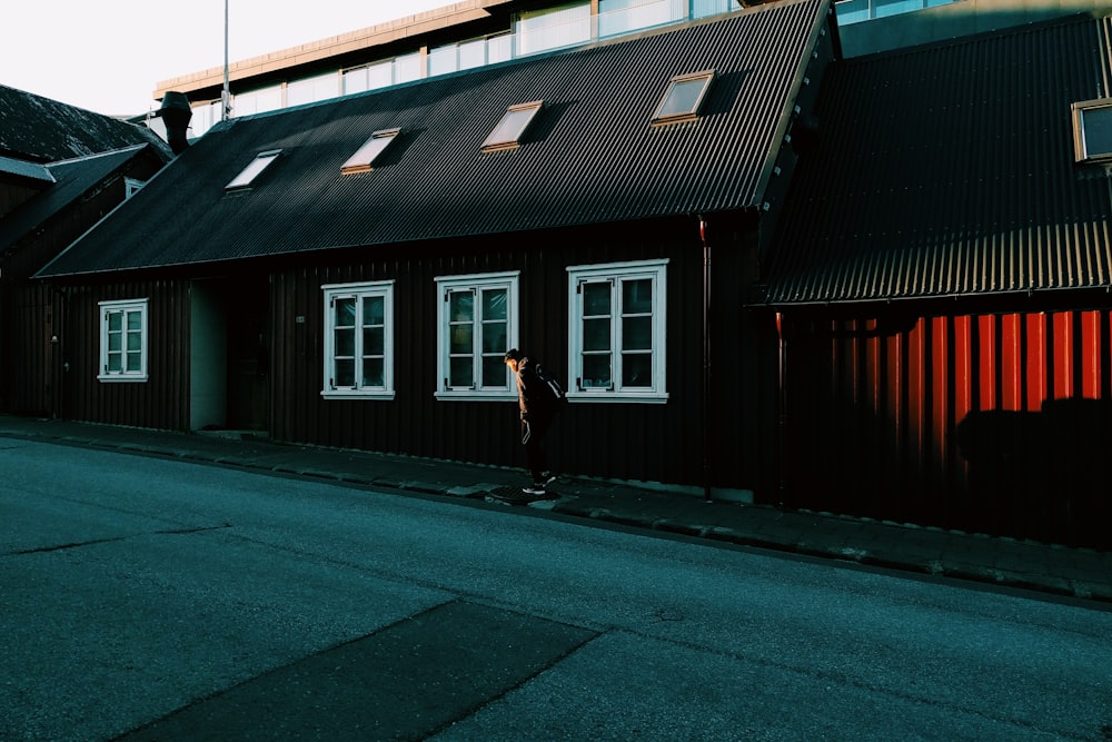 woman in black jacket walking on sidewalk during daytime