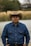 man in blue dress shirt wearing brown fedora hat