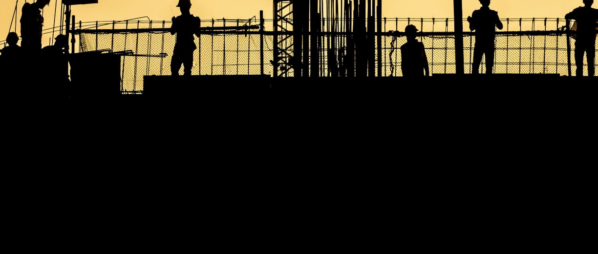 silhouette of people standing on tower crane during night time