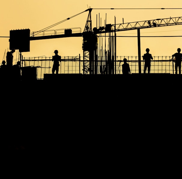 silhouette of people standing on tower crane during night time