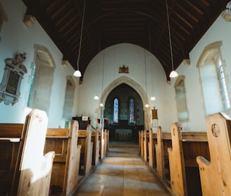 wooden pews inside church with arch background