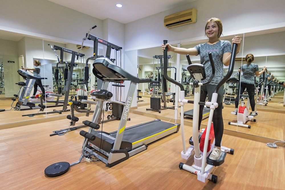 woman in gray long sleeve shirt standing on exercise equipment