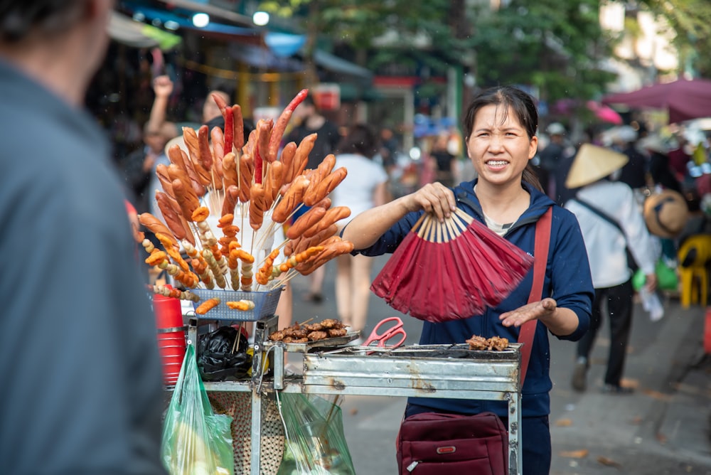 woman in blue and red dress holding brown and red plastic bags