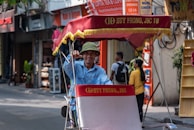 A smiling commuter stepping out of a TrustRide cab in front of a busy city street.