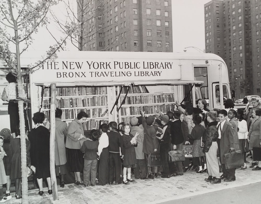 巡回中のニューヨーク公共図書館の近くに立つ人々のグレースケール写真