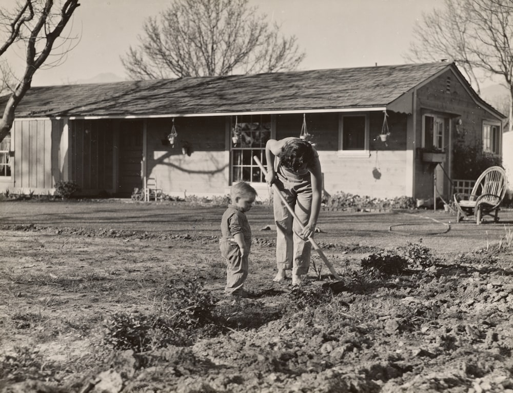 mother tending to soil while her son watches