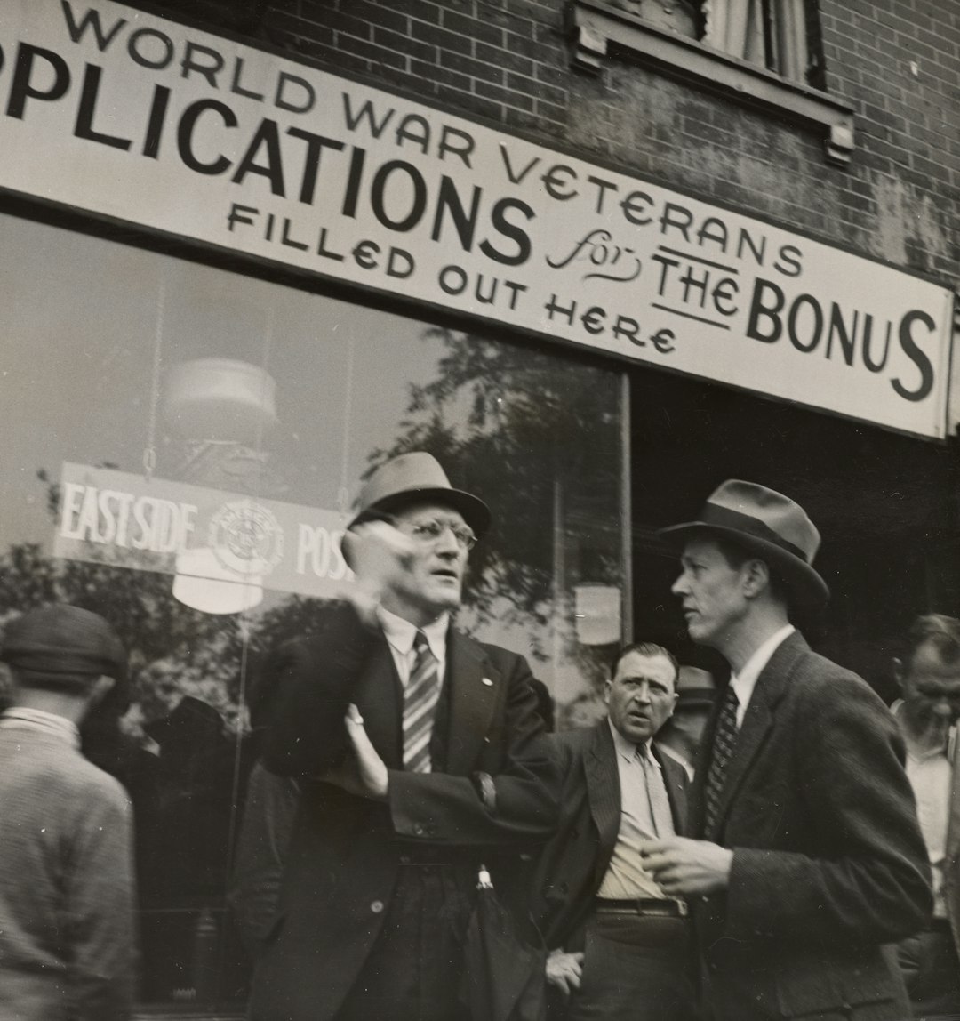 grayscale photo of man in black suit jacket standing beside man in black suit jacket