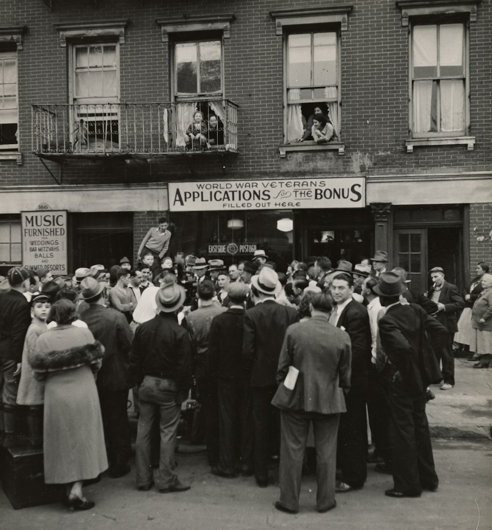 grayscale photo of people standing near the post office building