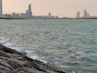 Fun line illustration of a city skyline blending into waves, representing tourism and travel.
