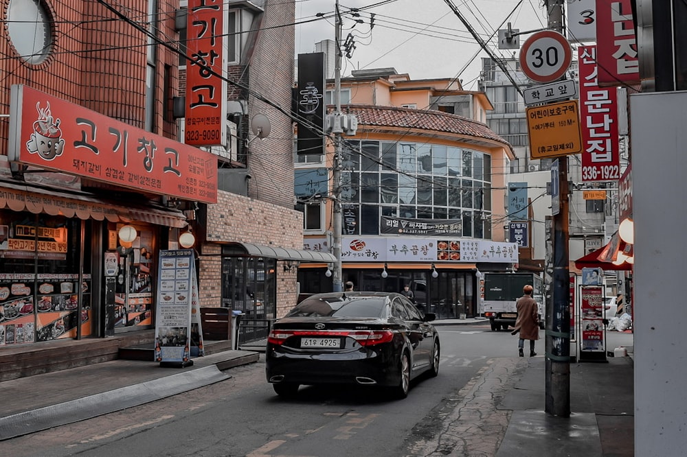 black car parked beside brown concrete building during daytime