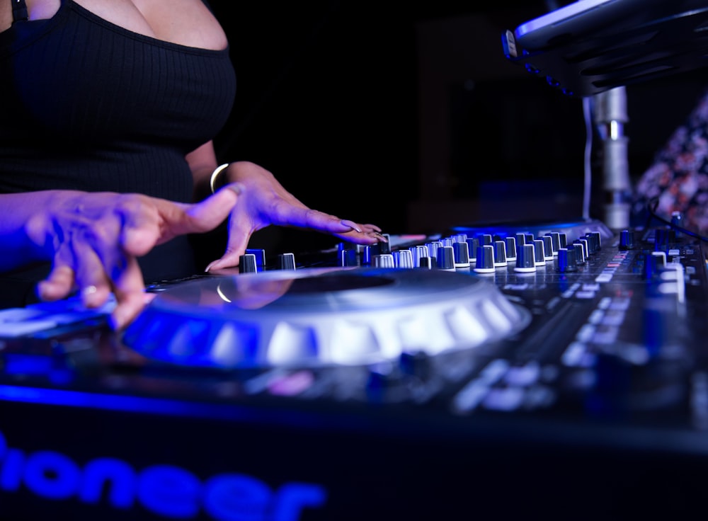 woman in black tank top playing dj mixer