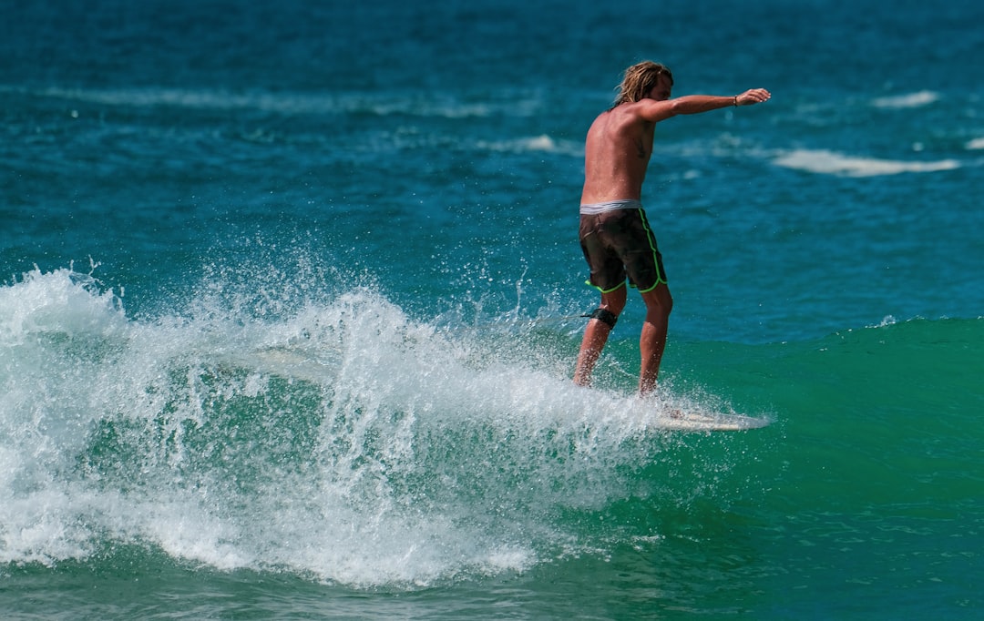 Longboarder surfing a longboard, riding the nose in Sri Lanka in tropical ocean sea.