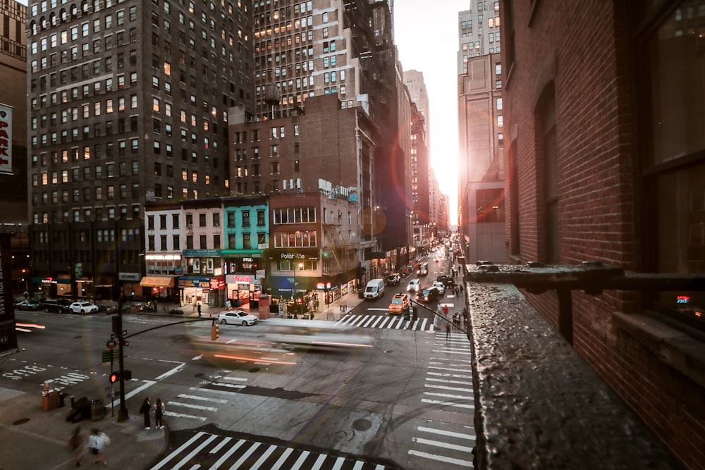 cars on road between high rise buildings during daytime