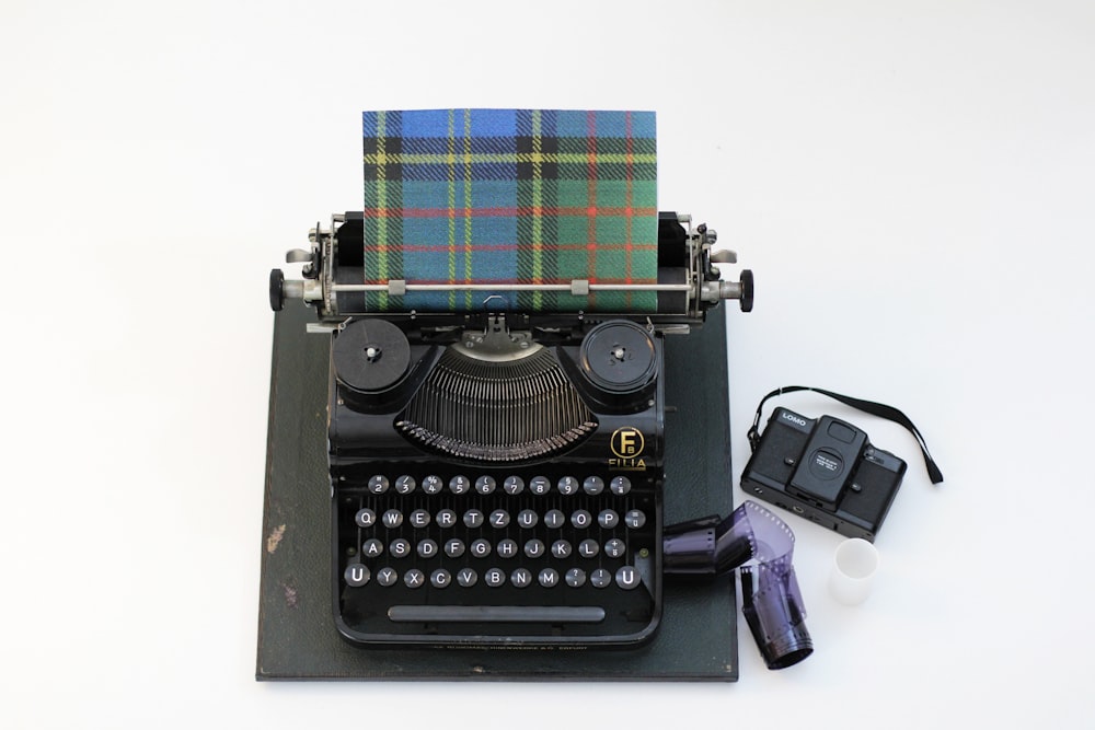 black and green typewriter beside purple and white plastic bottle