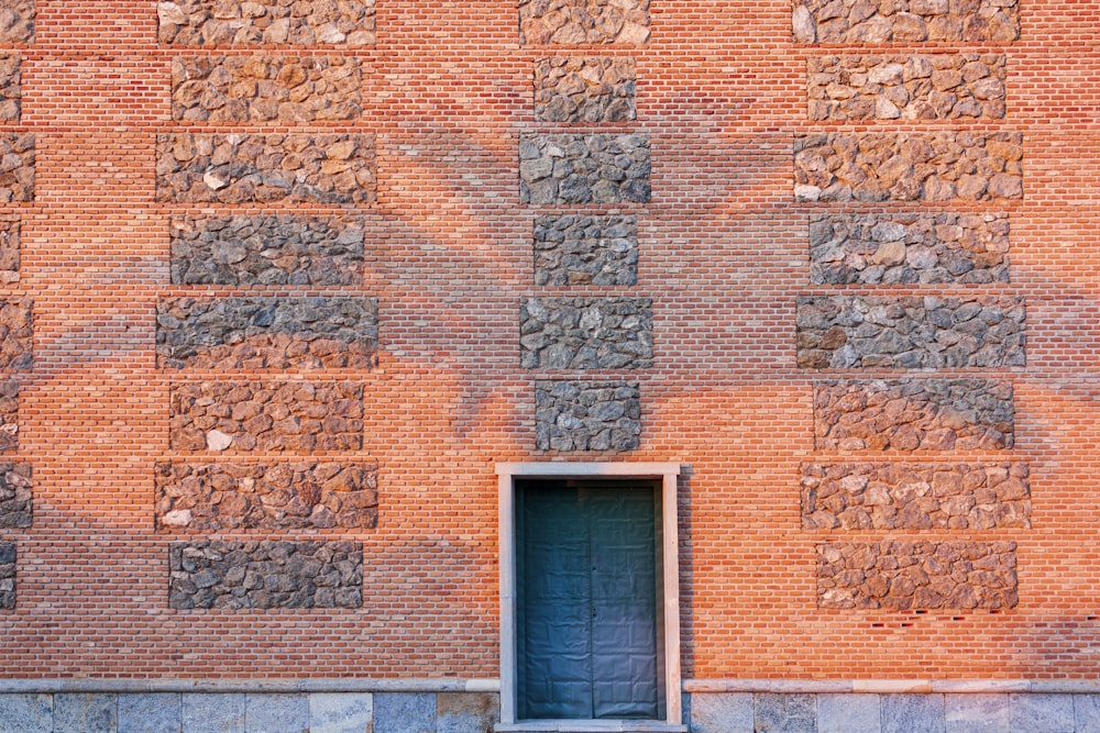 brown brick wall with blue wooden door