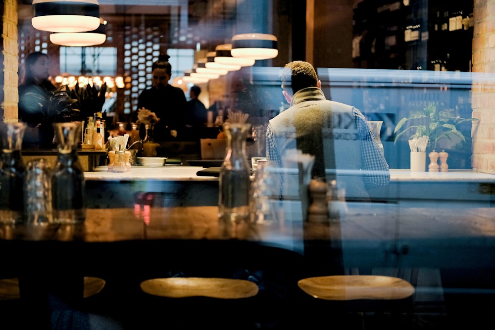 man in white dress shirt standing near table