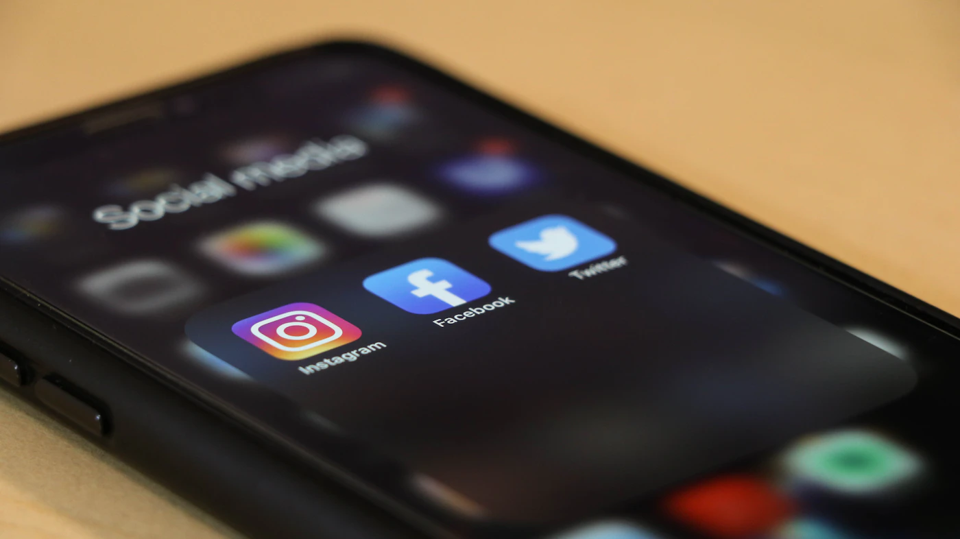 Telefon med sociale medier-apps på træbord
