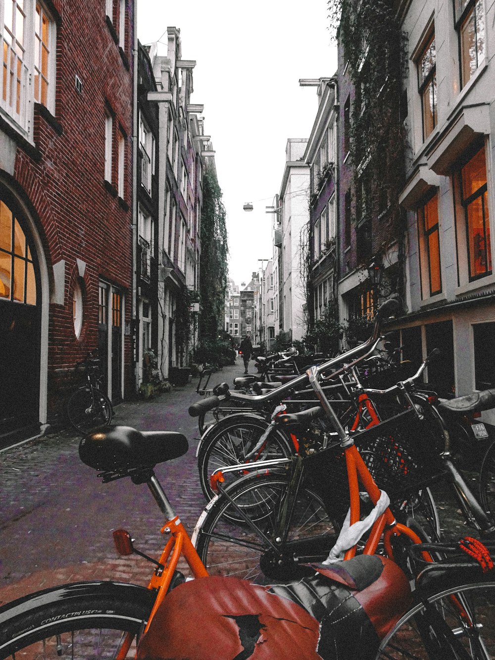 black and orange bicycles parked beside brown concrete building during daytime