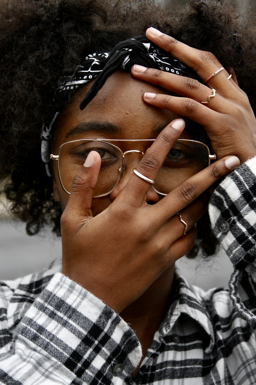 woman in white and black plaid shirt wearing gold framed eyeglasses